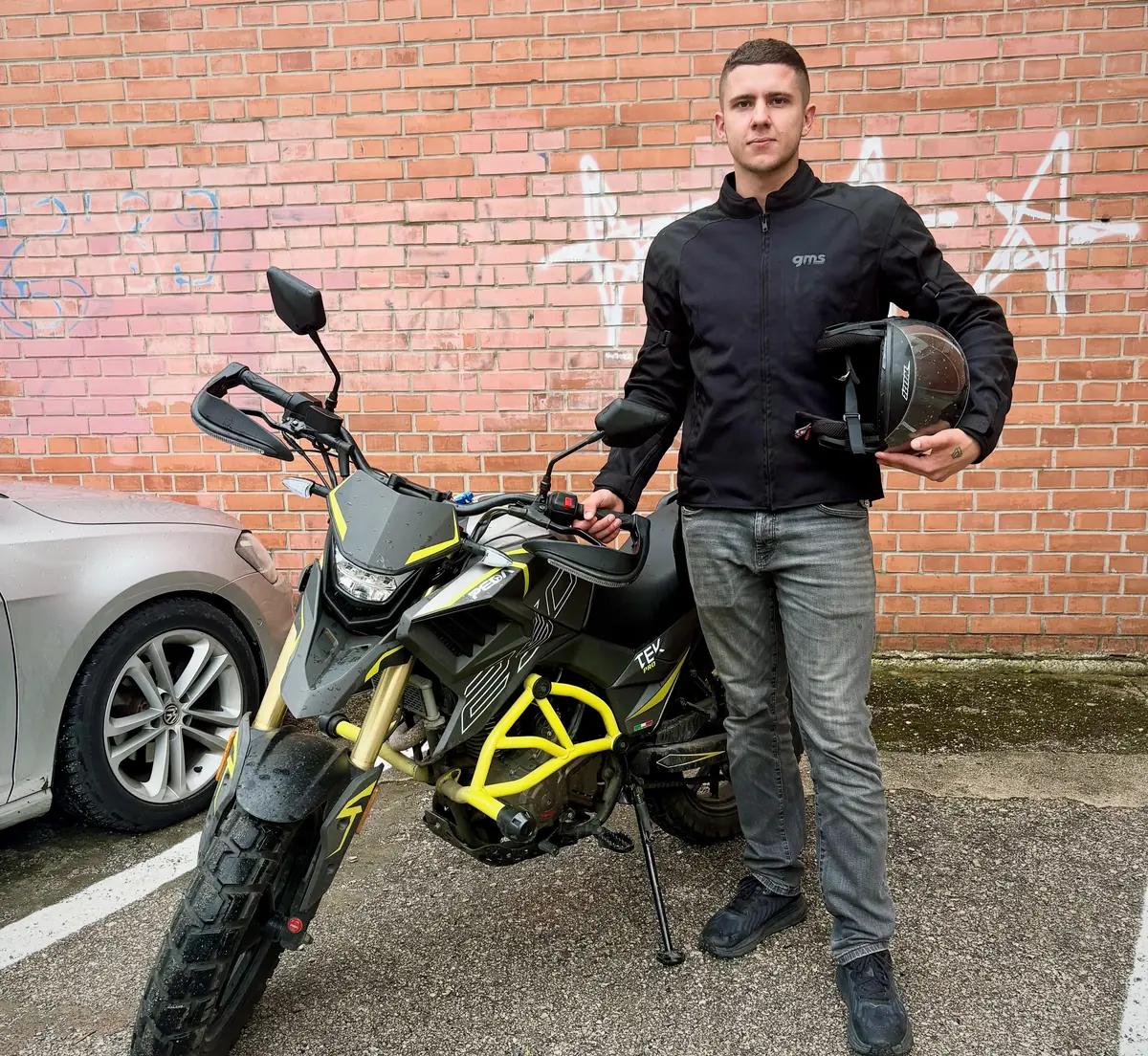 Kandidat s kacigom pored motocikla za obuku